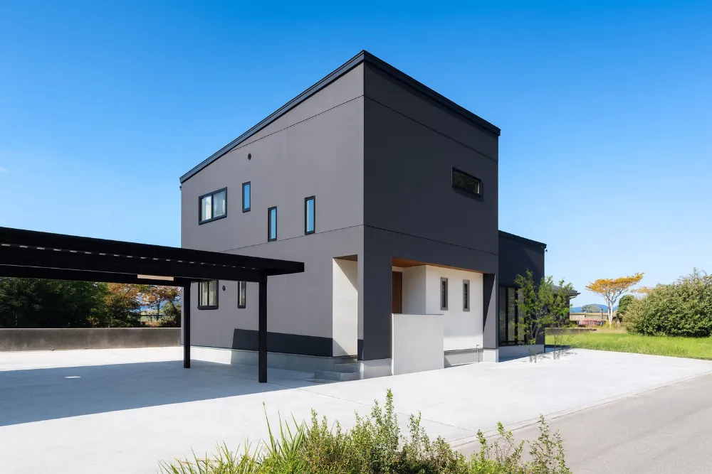 黒い外壁と大きな軒が迎える三世帯の家