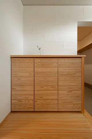 板張りの玄関収納と櫛引のしっくい壁